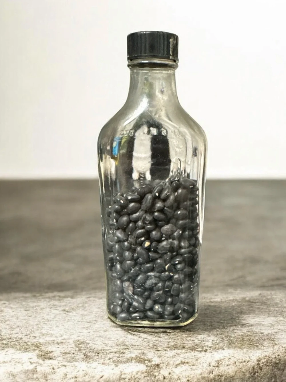 Clear Glass Decorative Bottle with Black Accent Contents
